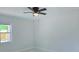 Bedroom featuring a ceiling fan, a window overlooking the yard and new white and gray tile flooring at 6475 Nw 61St Ave, Ocala, FL 34482