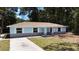 Beautiful light blue single-story home with white trim, brick base, and manicured lawn at 6475 Nw 61St Ave, Ocala, FL 34482