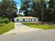 Charming light blue single-story home featuring a long driveway and mature landscaping at 6475 Nw 61St Ave, Ocala, FL 34482