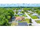Aerial view showcasing a home with a screened pool, mature trees, and a well-maintained neighborhood at 6631 Se 11Th Loop, Ocala, FL 34472