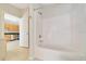 Clean bathroom shower with white tile and access to the kitchen at 6631 Se 11Th Loop, Ocala, FL 34472