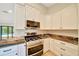 Modern kitchen with stainless steel range, granite counters, and white cabinets providing lots of storage at 6631 Se 11Th Loop, Ocala, FL 34472