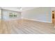 Open living room with a window, a door to the backyard and wood-look flooring at 6631 Se 11Th Loop, Ocala, FL 34472