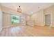 Bright living room with large windows, vaulted ceiling, and stylish light fixture at 6631 Se 11Th Loop, Ocala, FL 34472