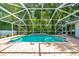 Sparkling in-ground pool with a screened enclosure and a paved deck at 6631 Se 11Th Loop, Ocala, FL 34472