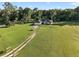 Expansive property featuring a single-story home and a lush green yard with mature trees at 6730 Sw 9Th Ave, Ocala, FL 34476