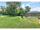 Spacious backyard featuring a screened pool enclosure, mature trees, and lush green lawn at 6730 Sw 9Th Ave, Ocala, FL 34476