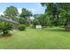 Expansive yard with mature trees, screened-in pool area, and detached shed at 6730 Sw 9Th Ave, Ocala, FL 34476