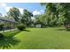 Lush backyard featuring a screened pool enclosure, mature trees, and a charming storage shed at 6730 Sw 9Th Ave, Ocala, FL 34476