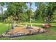 Backyard firepit with hammock chairs and bench seating, surrounded by natural landscaping and mature trees at 6730 Sw 9Th Ave, Ocala, FL 34476