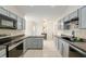 The kitchen has gray painted cabinets, modern appliances, and tile flooring at 6730 Sw 9Th Ave, Ocala, FL 34476