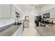 Kitchen featuring painted cabinets, modern appliances, tile floors, and a view of the living area at 6730 Sw 9Th Ave, Ocala, FL 34476