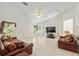 Large living room features tile floors, ceiling fan, and double doors leading to the exterior at 6730 Sw 9Th Ave, Ocala, FL 34476