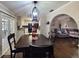 Cozy dining room area with dark wood floors and a view into the living room and kitchen at 6814 Se 53Rd Pl, Ocala, FL 34472