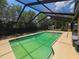 In-ground swimming pool with a screened enclosure featuring a concrete patio and backyard at 6814 Se 53Rd Pl, Ocala, FL 34472