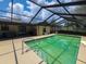 In-ground pool area featuring a screened enclosure, concrete patio, and backyard views at 6814 Se 53Rd Pl, Ocala, FL 34472