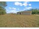 Backyard view of a single-story home featuring a covered patio and a spacious lawn at 7 Dogwood Trail Run, Ocala, FL 34472