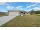 Charming single-story home showcasing a spacious lawn, attached garage, and inviting curb appeal at 7 Dogwood Trail Run, Ocala, FL 34472