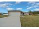 Single-story home featuring a long driveway, well-kept lawn, and attached two-car garage at 7 Dogwood Trail Run, Ocala, FL 34472