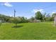 Large backyard with lush green grass, mature trees, a storage shed, and a charming tree at 713 Se 34Th Ter, Ocala, FL 34471