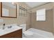 This bathroom features a tiled shower, tub and a modern vanity with a framed mirror and shelving unit at 713 Se 34Th Ter, Ocala, FL 34471