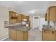 The kitchen features wood cabinets, laminate countertops, and a serving bar to the adjacent room at 713 Se 34Th Ter, Ocala, FL 34471