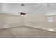 Spacious living room with neutral-toned walls, ceiling fan, and plush carpet flooring at 713 Se 34Th Ter, Ocala, FL 34471