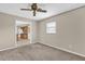 This living room has neutral walls and carpet. View into the kitchen at 713 Se 34Th Ter, Ocala, FL 34471