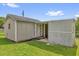 This outdoor shed has a small porch area, a back door, neutral paint, and is surrounded by green grass at 713 Se 34Th Ter, Ocala, FL 34471