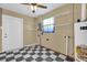 Utility room with checkered flooring, shelving, water heater, and natural light from a small window at 713 Se 34Th Ter, Ocala, FL 34471