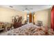 Comfortable bedroom featuring a patterned bedspread, dresser, and natural light, offering a tranquil retreat at 7443 Sw 102Nd Pl, Ocala, FL 34476