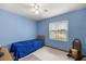 Cozy bedroom featuring a quaint bed, ceiling fan, and ample natural light from a window at 7443 Sw 102Nd Pl, Ocala, FL 34476