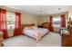 Inviting bedroom with natural light, neutral carpet and a comfortable bed complemented by colorful curtains at 7443 Sw 102Nd Pl, Ocala, FL 34476