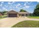 Charming single-story home with a brick facade, well-manicured lawn, and a spacious driveway at 7443 Sw 102Nd Pl, Ocala, FL 34476