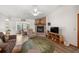 Cozy living room features a brick fireplace, wood floors, comfortable seating and plenty of natural light at 7443 Sw 102Nd Pl, Ocala, FL 34476