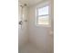 Tiled shower stall with a window and handheld shower head offering a bright and functional space at 7443 Sw 102Nd Pl, Ocala, FL 34476