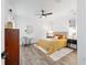 Cozy bedroom with wood-look flooring, ceiling fan, and large mirror at 9746 Sw 108Th Terrace Rd, Ocala, FL 34481