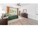 Bright bedroom with a large window, wood-look flooring, neutral rug and ensuite bathroom at 9746 Sw 108Th Terrace Rd, Ocala, FL 34481