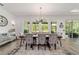 Bright dining room featuring a modern chandelier, floor-to-ceiling windows and neutral decor at 9746 Sw 108Th Terrace Rd, Ocala, FL 34481