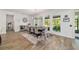 An open dining room features wood floors, an area rug, and views of a screened-in porch at 9746 Sw 108Th Terrace Rd, Ocala, FL 34481