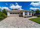 This lovely home features a two-car garage, stone driveway, manicured lawn, and elegant shutters at 9746 Sw 108Th Terrace Rd, Ocala, FL 34481