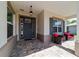Cozy covered porch features a pendant light, door with sidelights, and comfortable seating area at 9746 Sw 108Th Terrace Rd, Ocala, FL 34481