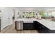 Open kitchen with white cabinets, black island base, and stainless steel dishwasher at 9746 Sw 108Th Terrace Rd, Ocala, FL 34481