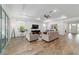 Bright, open living room with tray ceiling, wood flooring, and large windows, perfect for entertaining at 9746 Sw 108Th Terrace Rd, Ocala, FL 34481