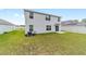 Spacious backyard with lush green grass and a modern white house exterior at 11205 Se 69Th Ter, Belleview, FL 34420