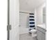 Well-lit bathroom with a tub, shower, blue striped curtain, and a modern vanity with a marble countertop at 11205 Se 69Th Ter, Belleview, FL 34420