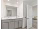 Elegant bathroom featuring double sinks, gray cabinets, and tile floors at 11205 Se 69Th Ter, Belleview, FL 34420