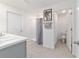 Bathroom features a shower with a gray shower curtain, a sink with white counter, and a toilet in an adjacent room at 11205 Se 69Th Ter, Belleview, FL 34420