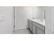 Bathroom featuring a double sink with gray cabinets and gray tile floors at 11205 Se 69Th Ter, Belleview, FL 34420