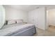 Bright bedroom featuring neutral tones, plush bedding, and a double-door closet for ample storage space at 11205 Se 69Th Ter, Belleview, FL 34420
